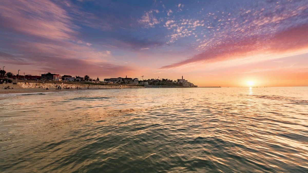 An enchanting coastal view at sunset with vibrant skies and calm waters, perfect for travel and nature themes.