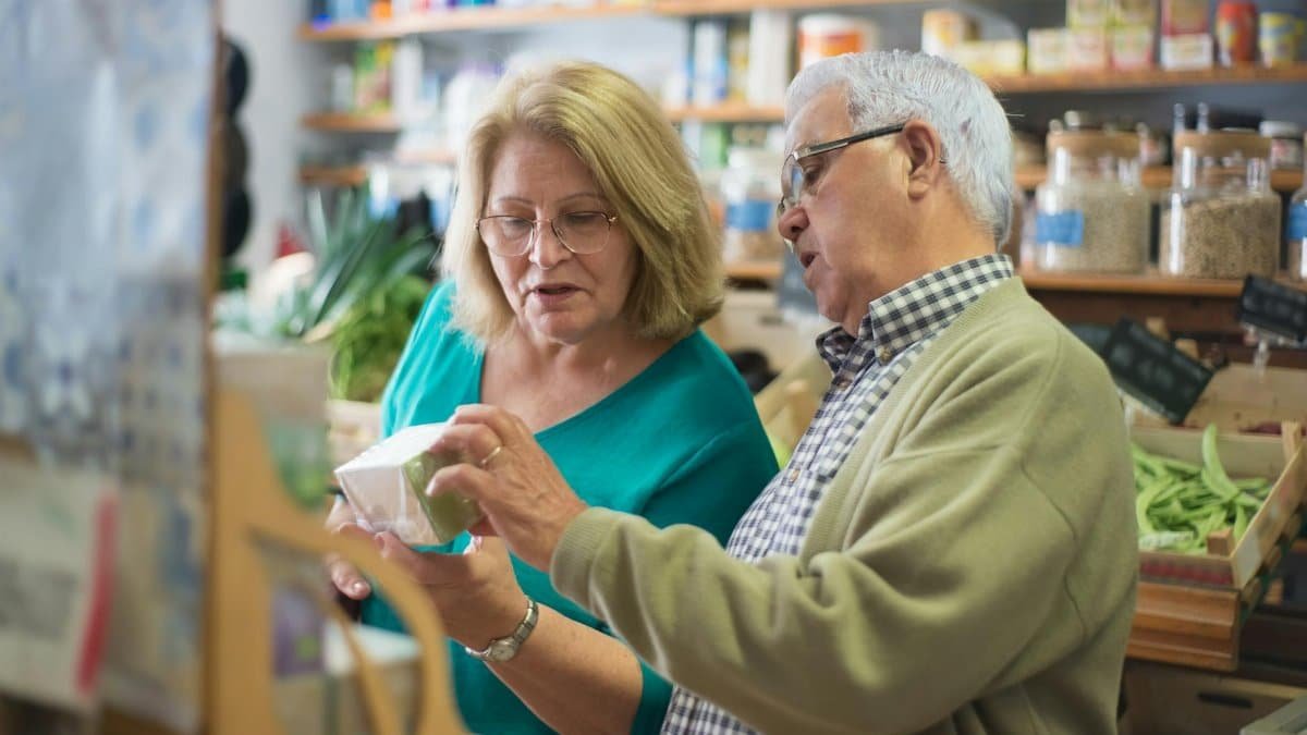An elderly couple explores products inside a local store in Portugal, highlighting everyday life.