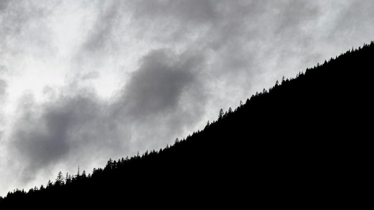 Dramatic monochrome silhouette of a mountain against a cloudy sky in Cowichan Bay, BC.