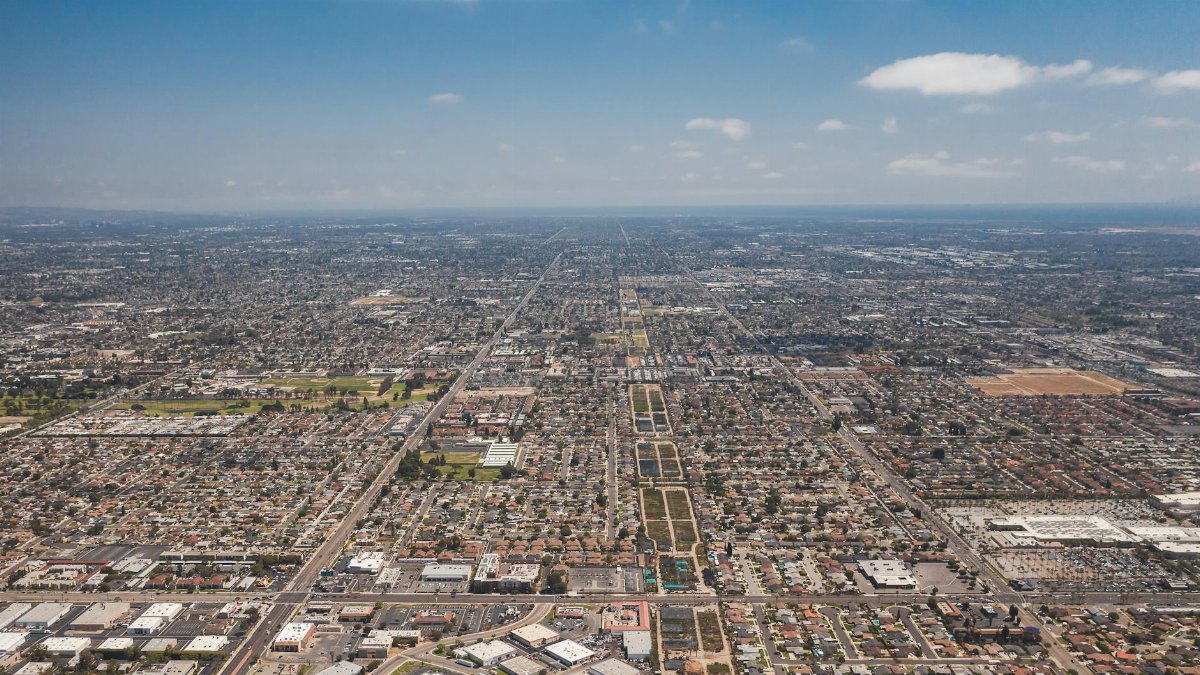 Expansive aerial view of Los Angeles urban landscape under a clear blue sky.