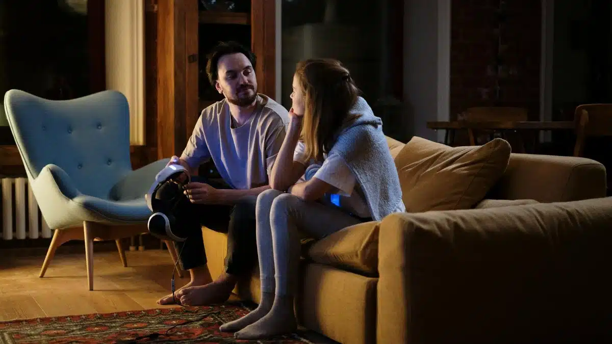 A couple enjoys a relaxing evening at home, using VR goggles on the couch.