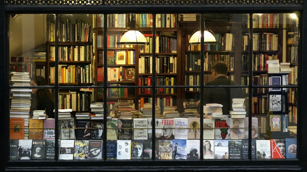 A cozy London bookstore showcasing various books through a classic window display.