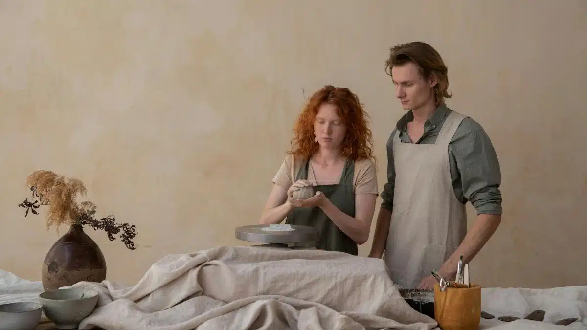 Couple crafting pottery in an artistic studio with focus on ceramic art creation.