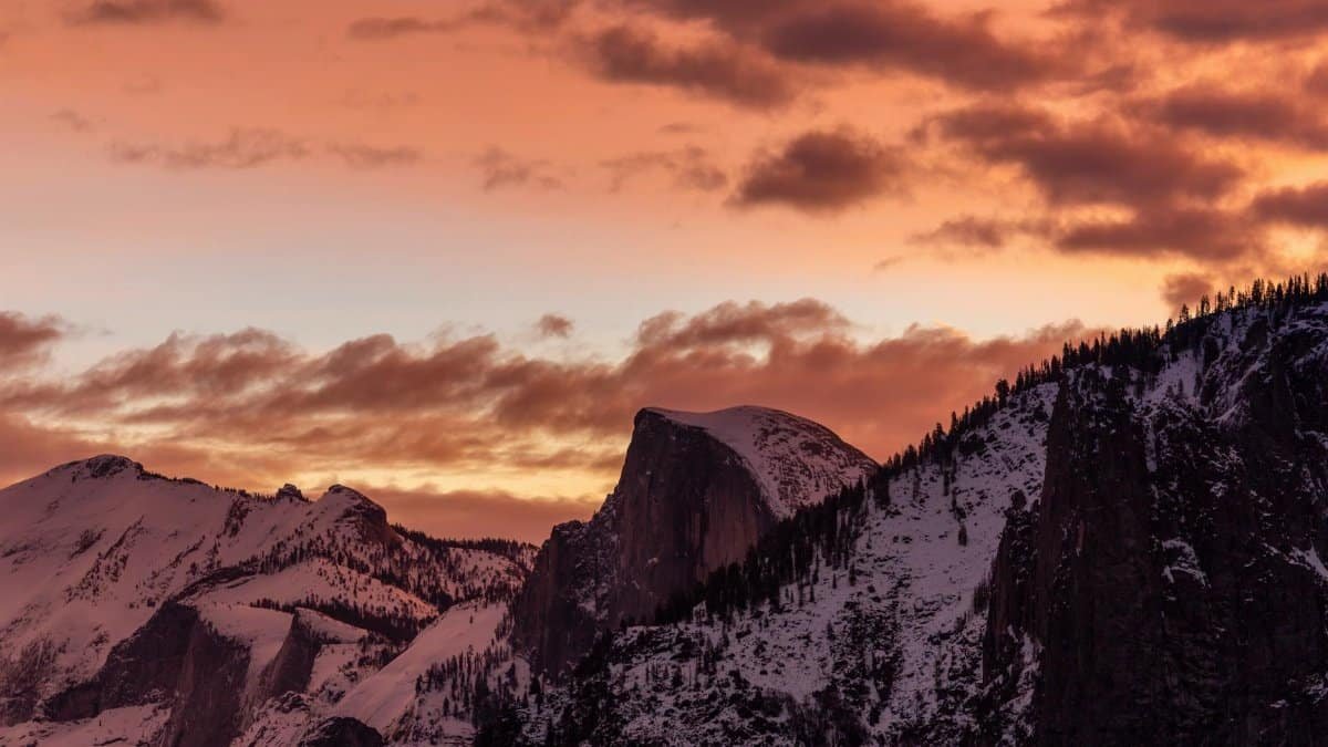 Breathtaking view of Half Dome at sunset in Yosemite National Park. Captured in winter with snow-capped peaks.