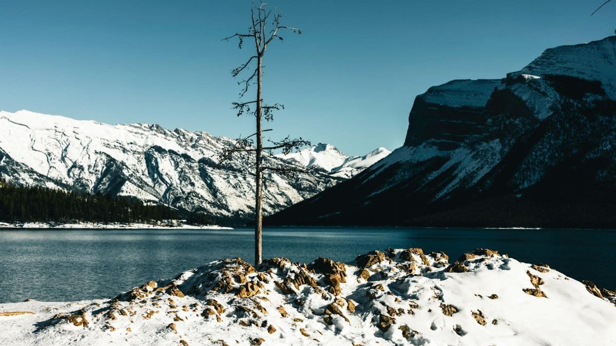 Explore the stunning winter landscape of Glacier National Park with snow-capped mountains and serene lake views.