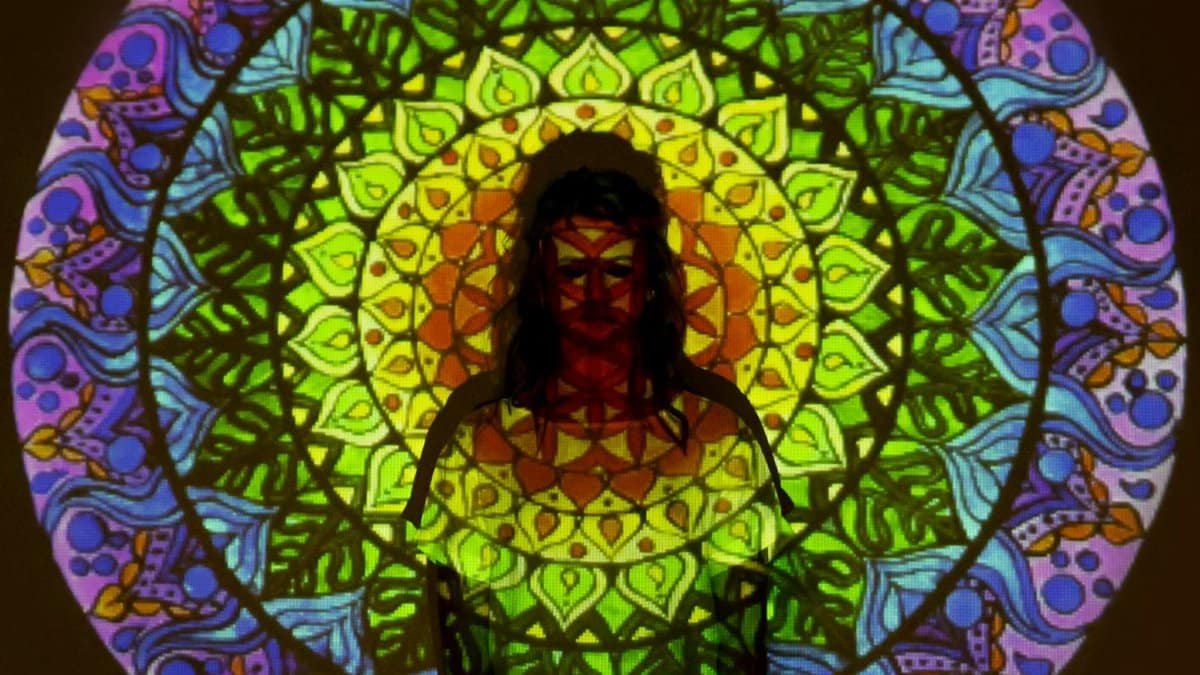 Colorful mandala projection on a silhouette, blending intricate patterns and vibrant hues.