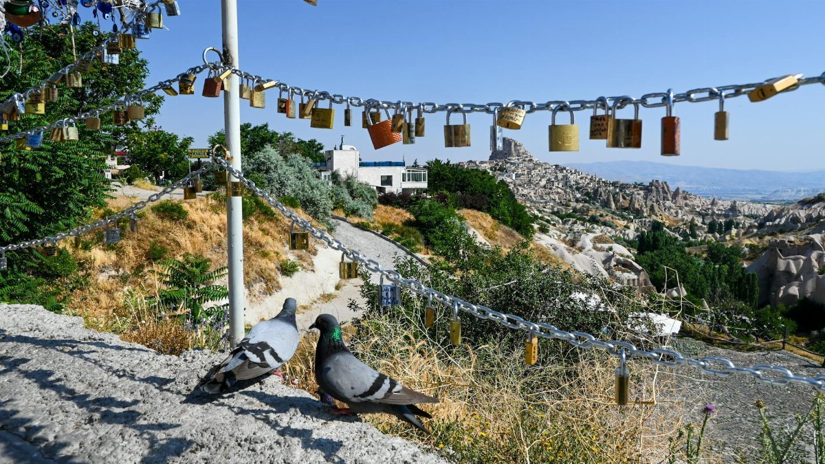 Pigeons on a wall with love locks and stunning view of Cappadocia, Turkey.