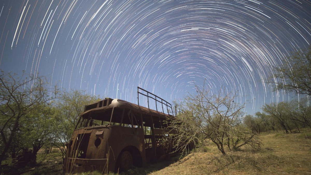 A stunning capture of star trails over a rusty abandoned bus in Fitzroy Crossing, Western Australia.