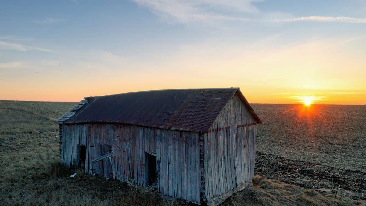 Scenic rural Minnesota landscape featuring an abandoned barn at sunrise, capturing serene beauty.