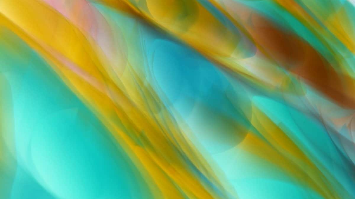 Dynamic abstract artwork with flowing colors, featuring teal and gold hues, reminiscent of ocean waves.