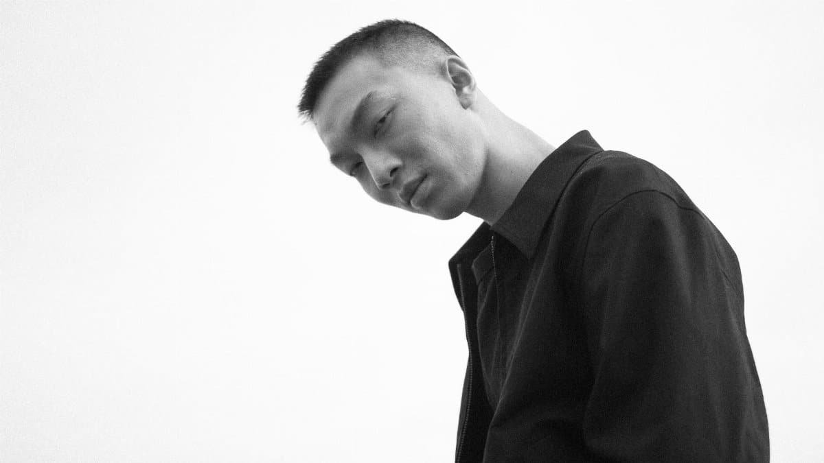 Low angle black and white portrait of a man wearing a black jacket.