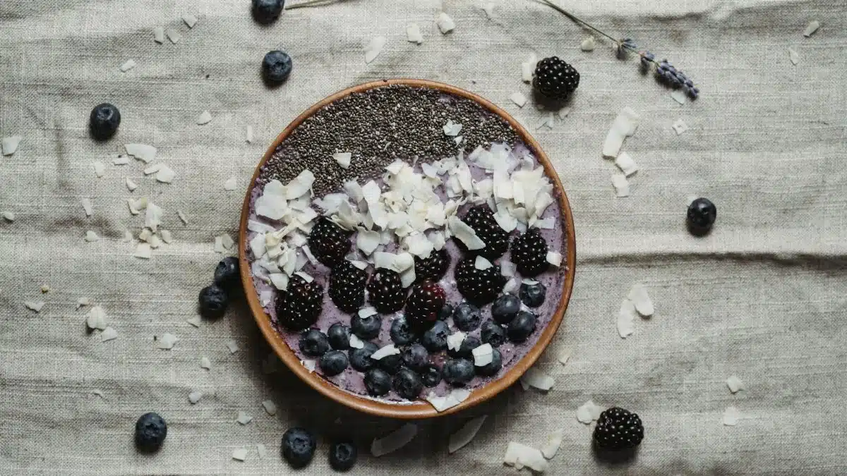 A nutritious berry smoothie bowl topped with chia seeds, blackberries, blueberries, and coconut flakes.