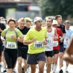 A diverse group of runners actively participating in a marathon on a city street during the day.