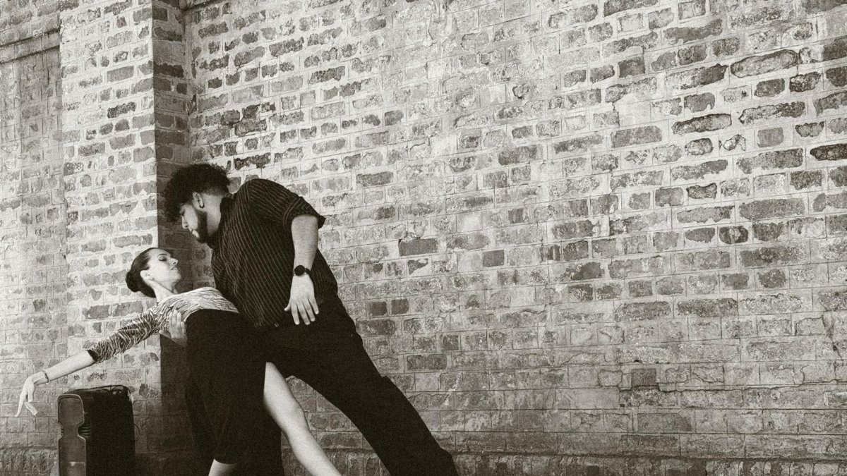 Captivating tango dancers performing in front of a brick wall in Buenos Aires, Argentina.