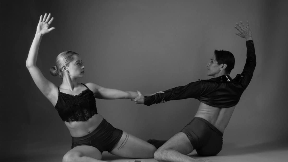 Black and white artistic photo capturing a couple performing contemporary dance in an elegant pose.