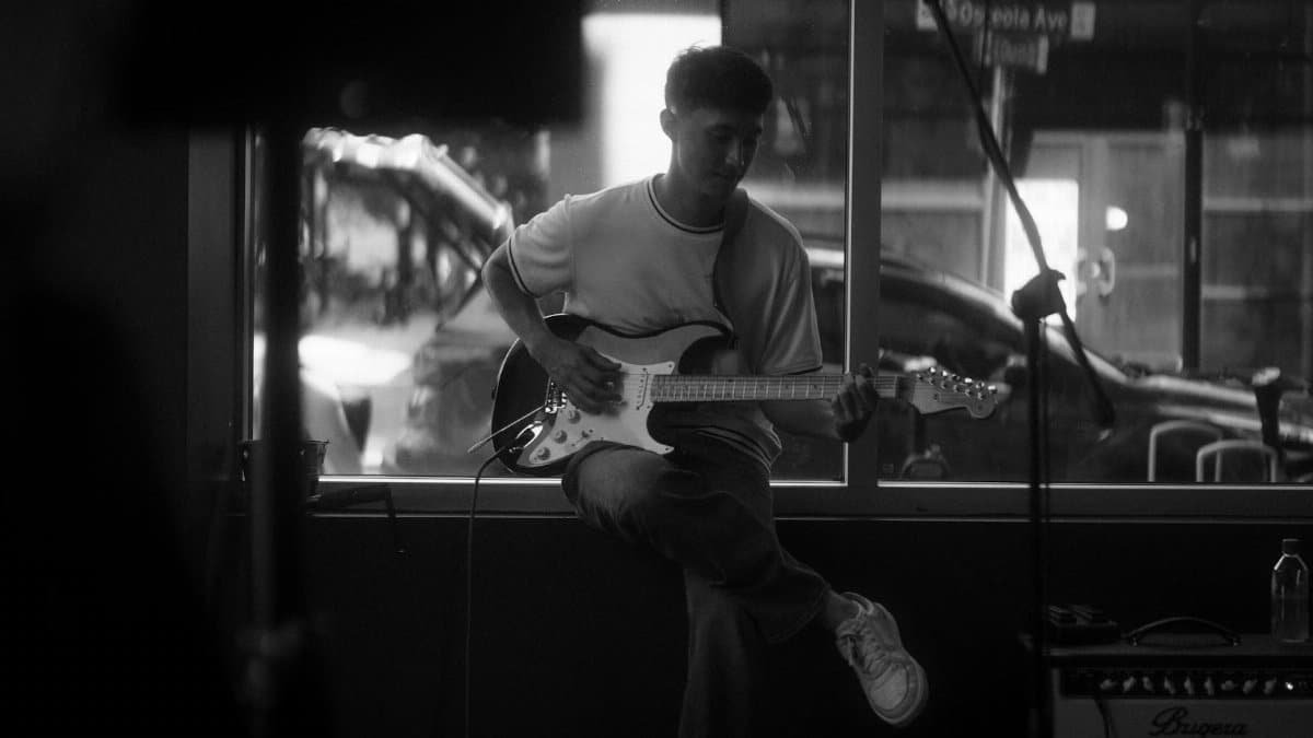 A guitarist performing intimately indoors with a focus on musical expression.