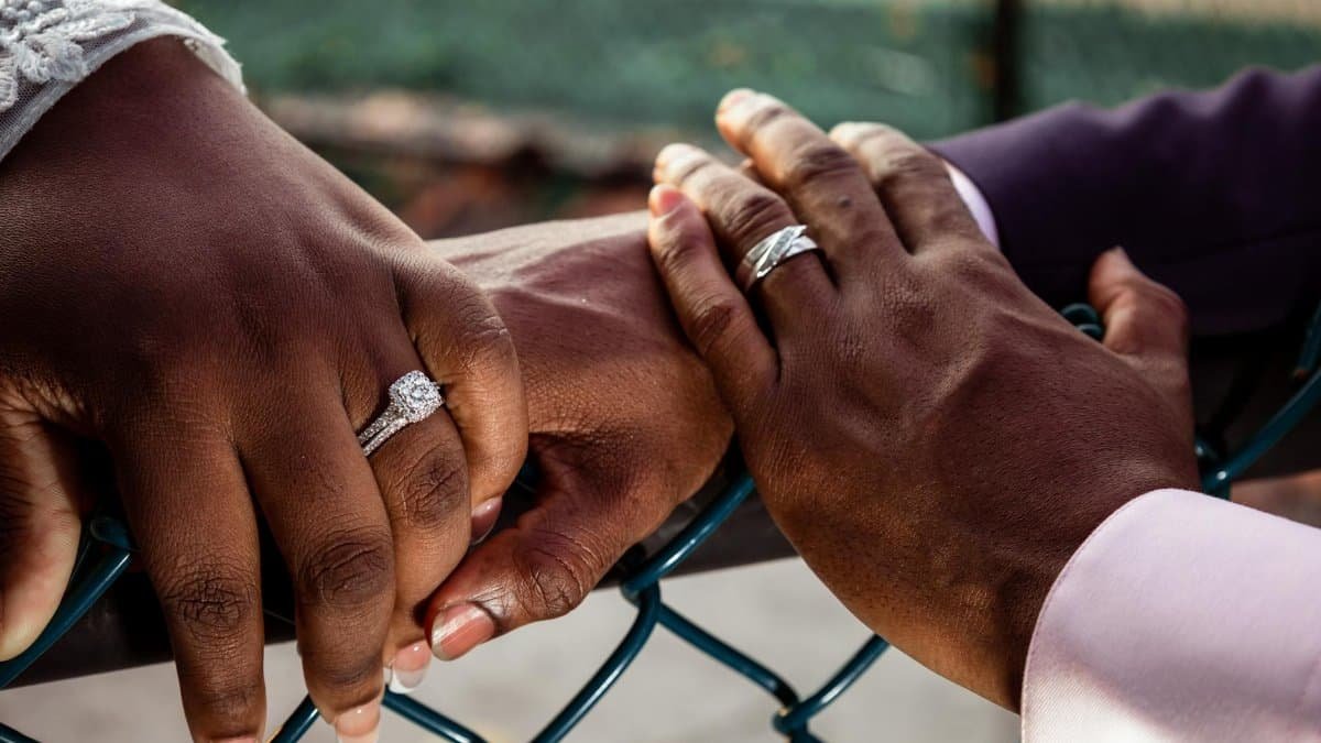 Close-up of a couple's hands with wedding rings, symbolizing love and commitment.