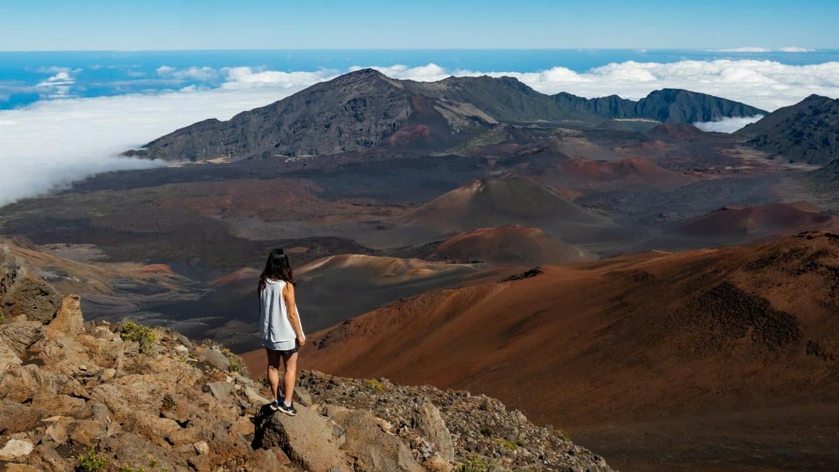 Woman hiking in Haleakalā National Park, enjoying scenic volcanic landscape in Maui, Hawaii.