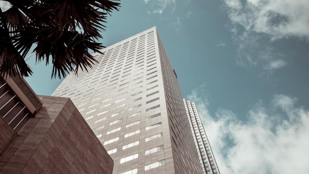 Tall modern building with glass windows against a blue sky in Miami.