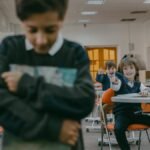 A group of children laughing and pointing at a sad classmate in a school library.