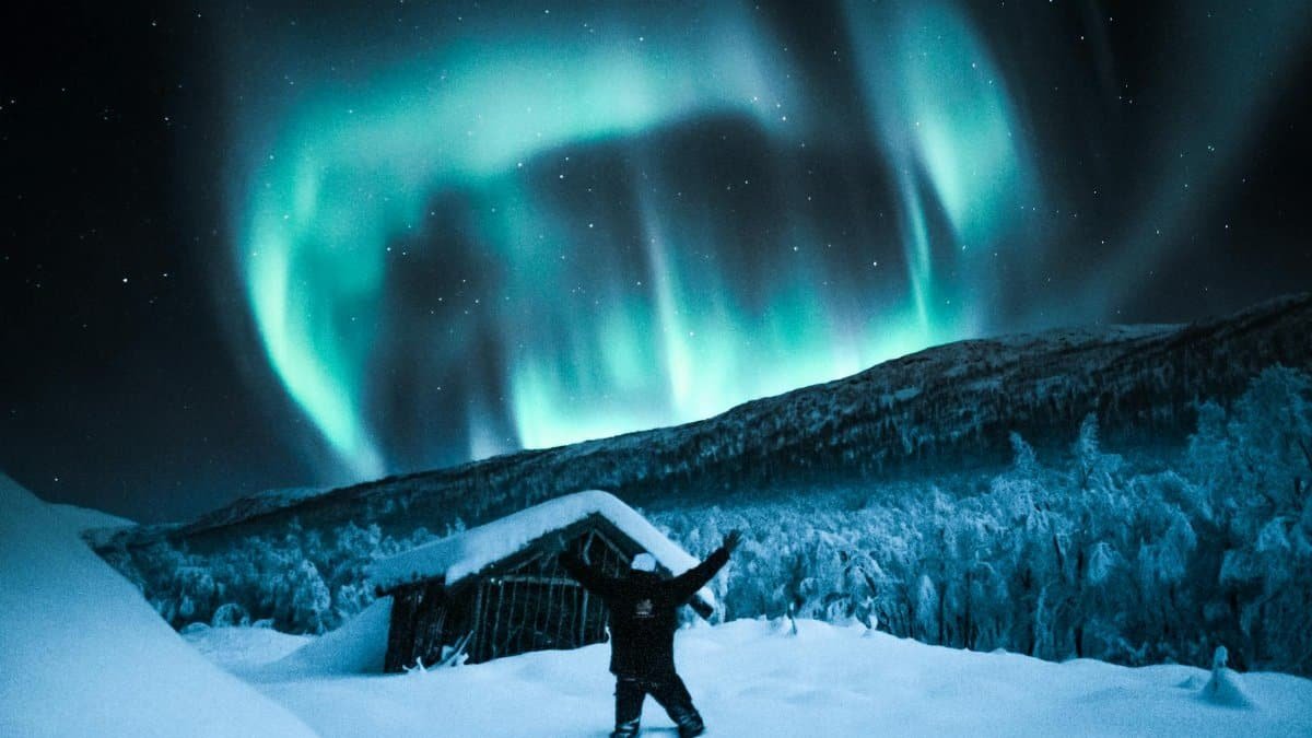 Vibrant northern lights illuminate a winter night sky in snowy Norway. Perfect for travel and nature enthusiasts.