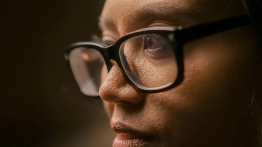 A close-up image capturing a person in a thoughtful mood, highlighting eyeglasses.