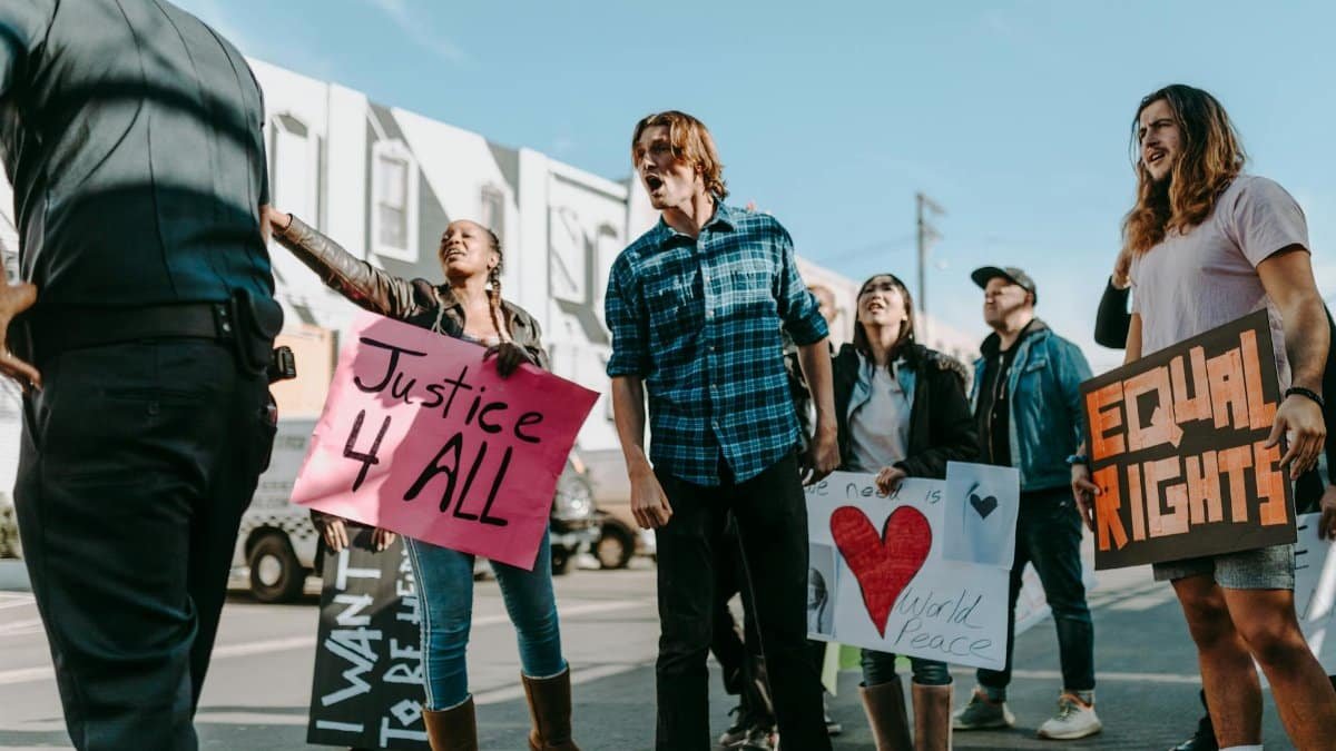 Diverse group of protesters holding signs advocating justice and peace in a peaceful rally.