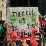 A large crowd gathers in Vancouver to protest for democracy and freedom, holding signs and flags.