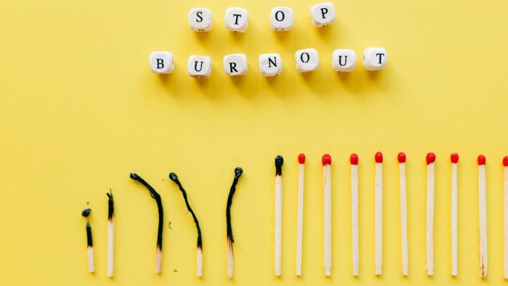 Conceptual image of burnout prevention with matches and letters on yellow background.