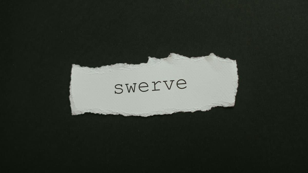 Close-up of torn paper with the word 'swerve' on a black background, ideal for concepts of change and direction.
