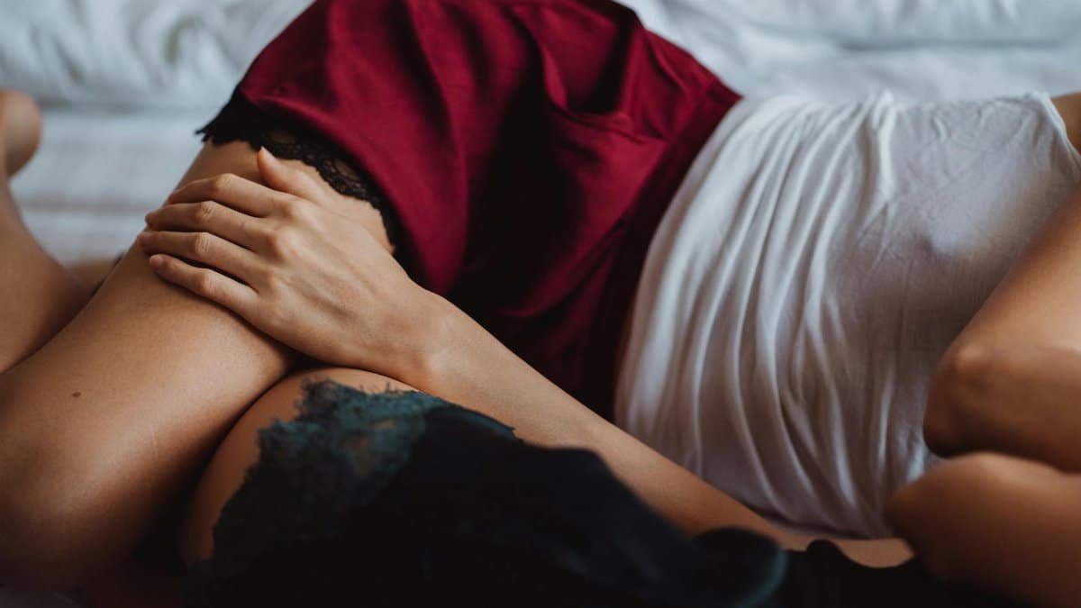 A close-up of a couple cuddling on a bed, symbolizing love and intimacy.