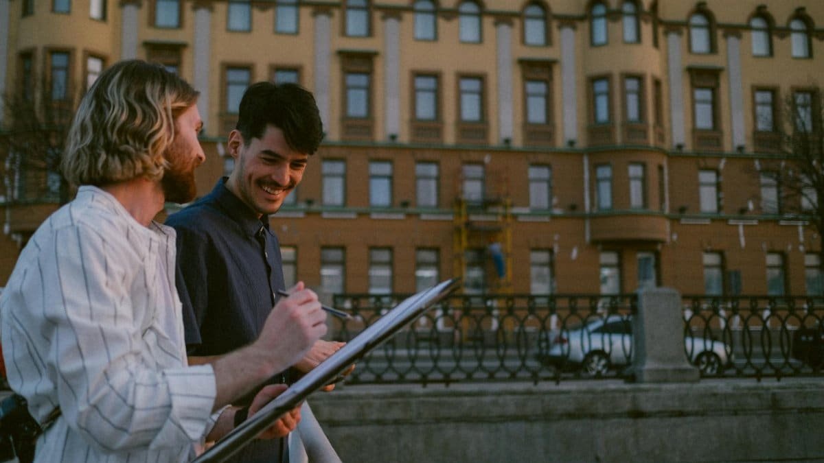 Two men engaging in conversation outdoors during dusk in an urban city setting, depicting everyday life.