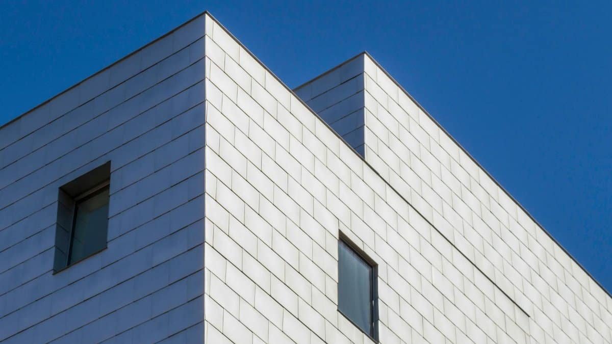 Low angle view of a modern building's facade with glass windows against a blue sky in Minneapolis.
