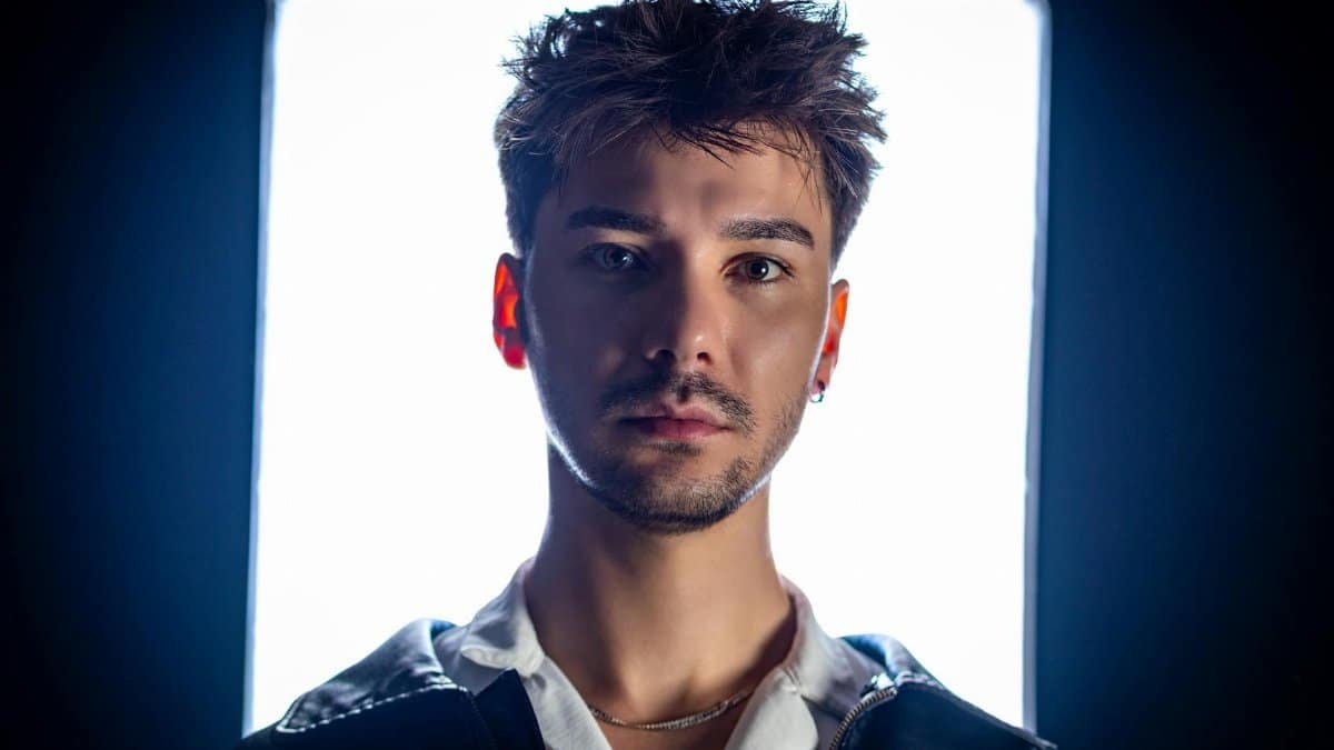 Close-up portrait of a young man in studio lighting with a bright background.