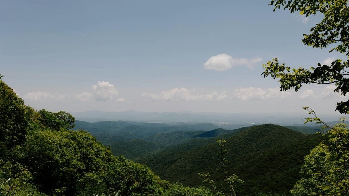 Breathtaking panorama of lush green Appalachian Mountains under a blue sky in Asheville, NC.