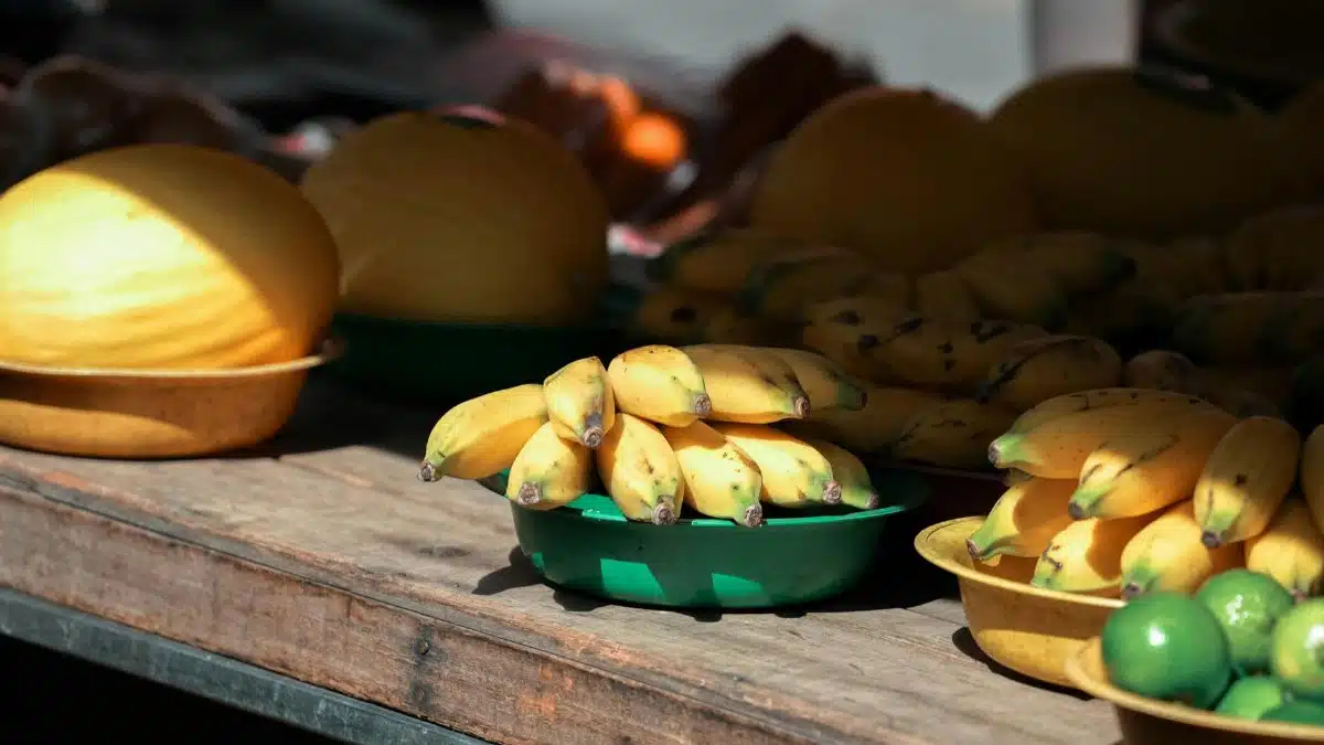 Vibrant display of fresh bananas and limes at an outdoor market in Espírito Santo, Brazil.