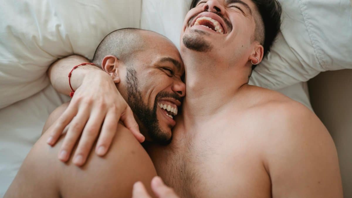 Loving and joyful moment between an affectionate couple relaxing and laughing together indoors.