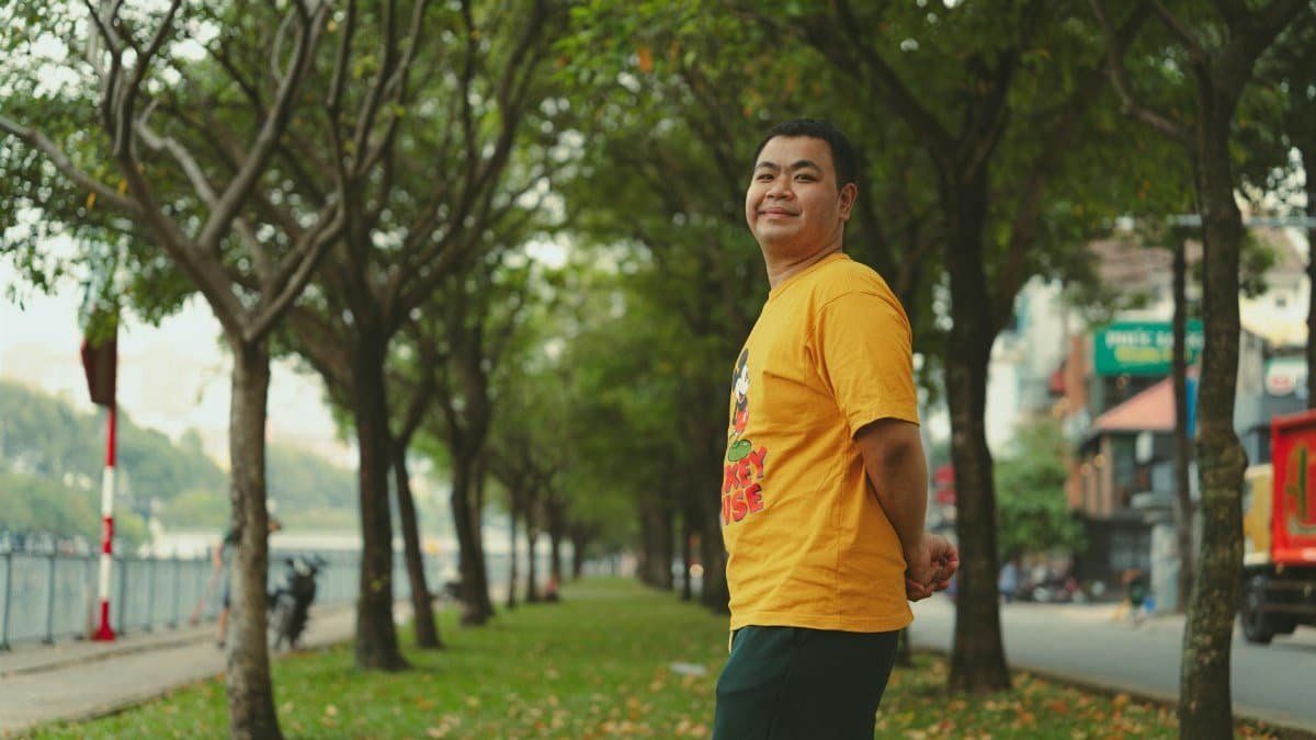 A man enjoying a walk in a green park in Ho Chi Minh City, Vietnam on a sunny day.