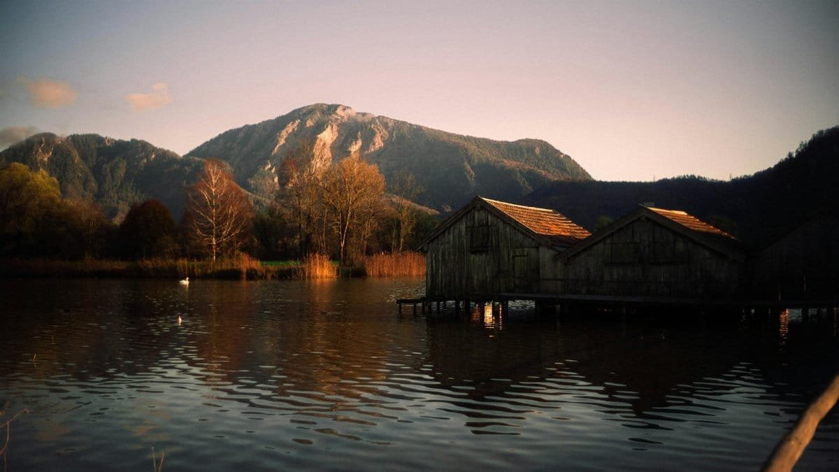 Serene lakeside cabins with mountain views at sunset, perfect for peaceful retreats.