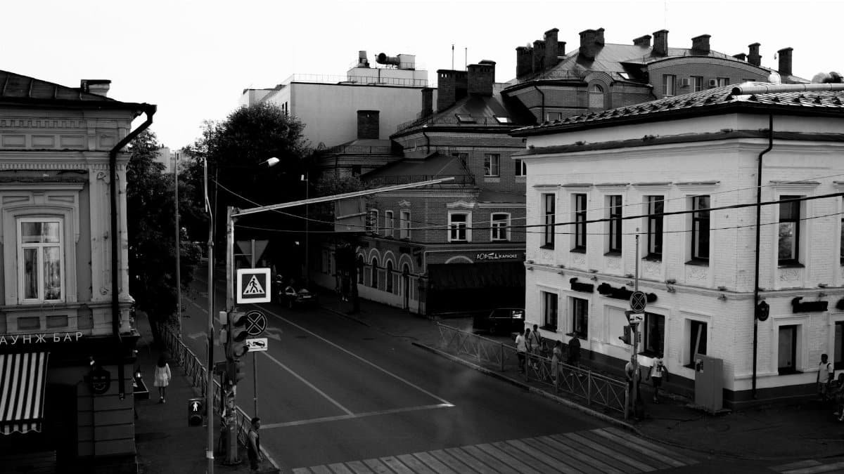 An evocative black and white photograph of a quiet urban street corner.