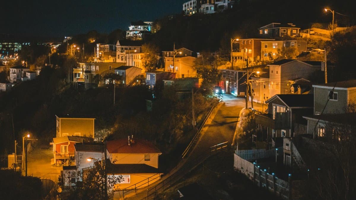 City with small settlement of cottages with bright lights in late clear evening