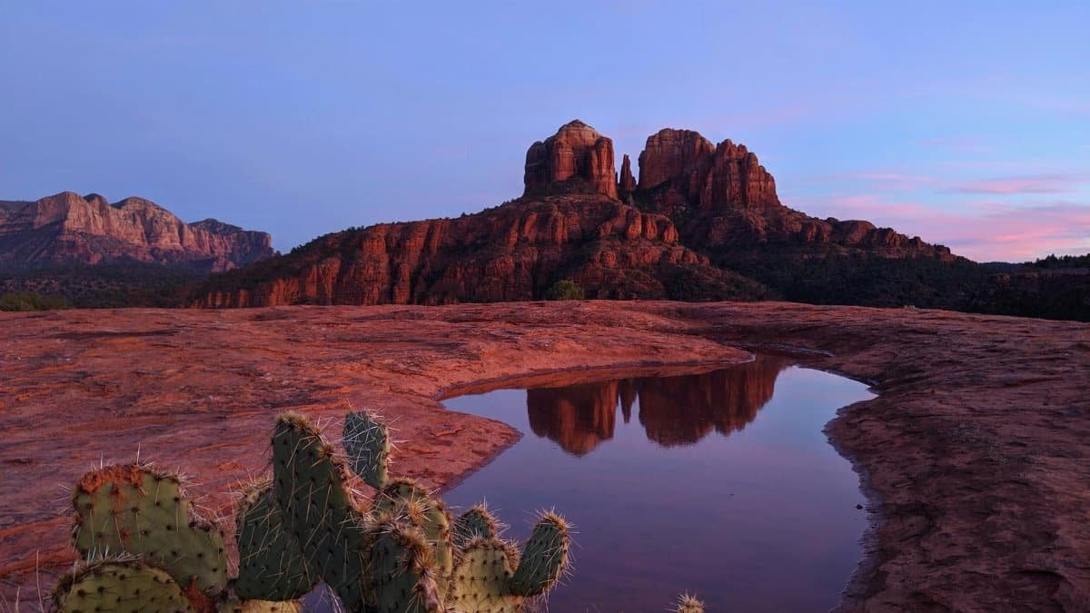 Stunning view of Cathedral Rock in Sedona, Arizona, reflecting in a puddle during sunset.