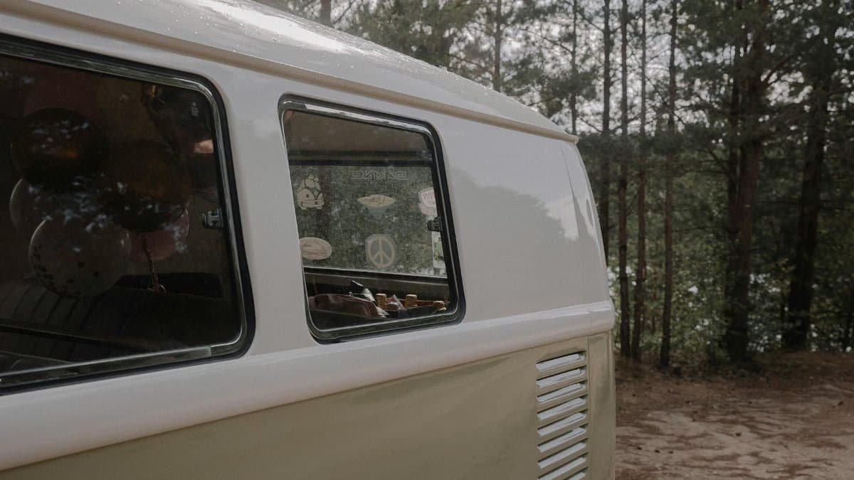 Retro Volkswagen van parked in a serene forest setting, capturing a nostalgic vibe.