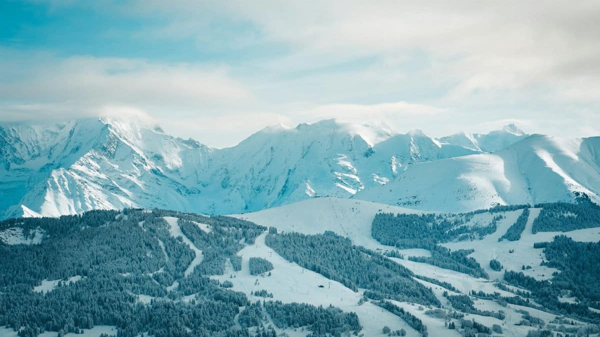 A serene winter landscape showcasing snow-covered mountains and forests in Megève, France.