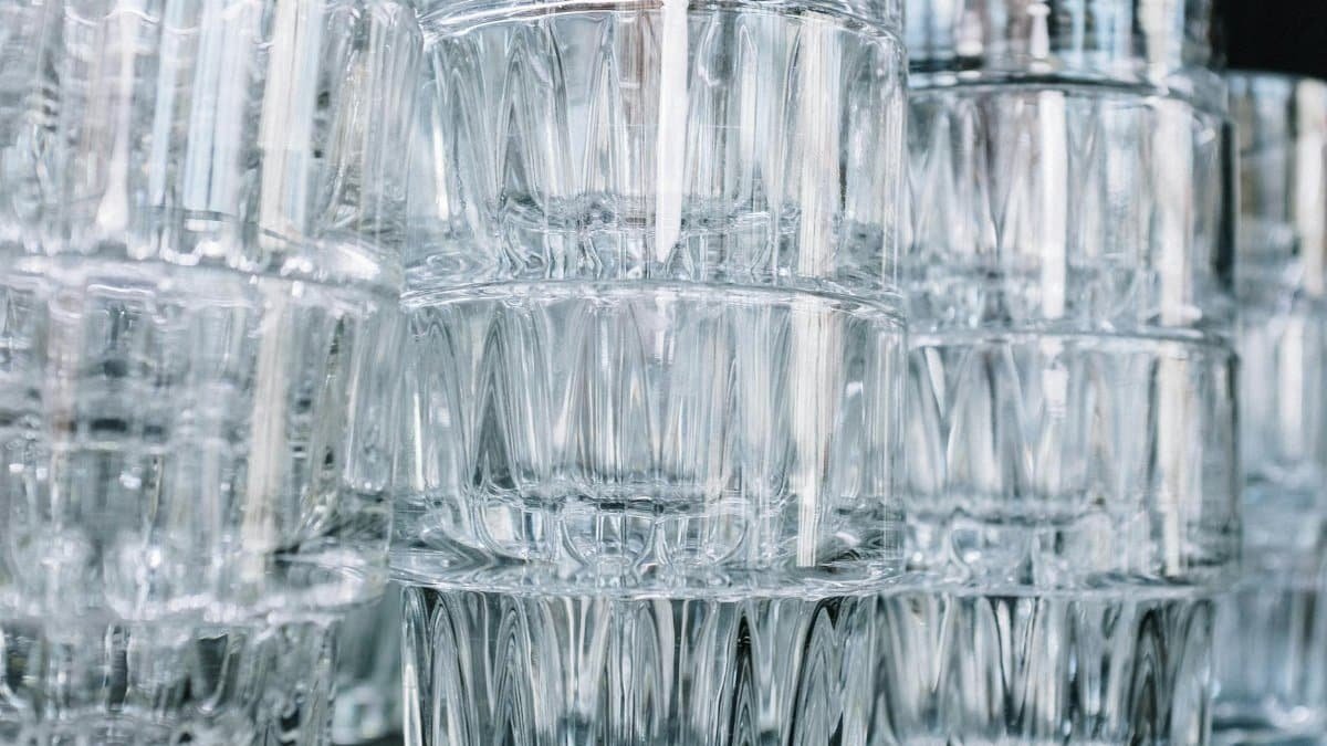 Close-up of stacked clear glasses with a focus on their intricate patterns and reflections.