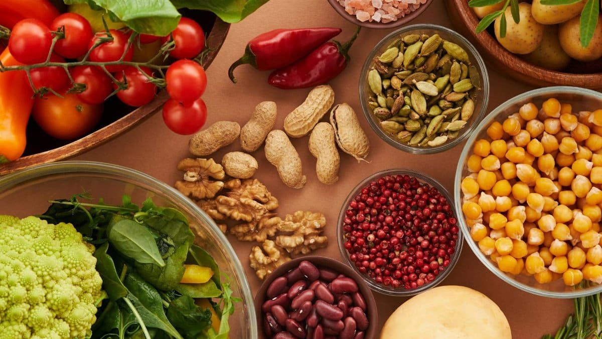Explore a colorful assortment of healthy ingredients, featuring vegetables, nuts, seeds, and spices in a top view layout.