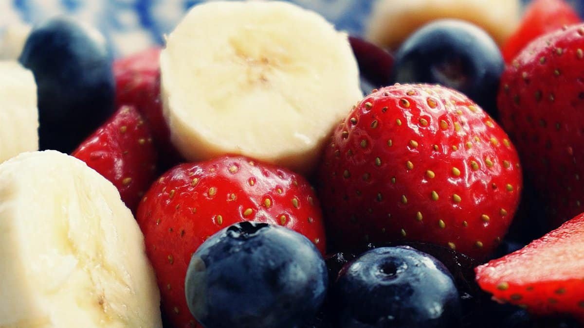 Close-up of fresh bananas, strawberries, and blueberries. Perfect for health and diet themes.