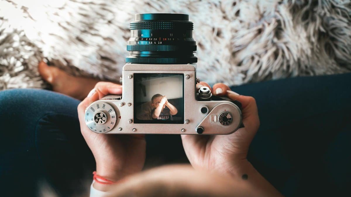 A vintage camera capturing a cherished moment of a child indoors on a cozy day.