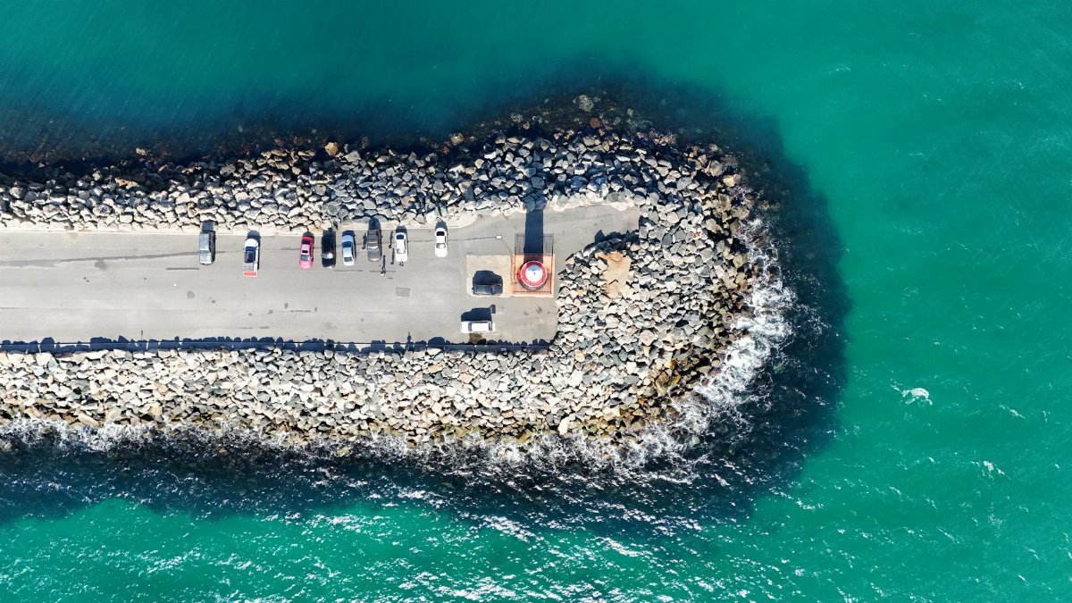 Explore a stunning aerial view of a coastal pier surrounded by vibrant blue ocean in Perth, WA, Australia.