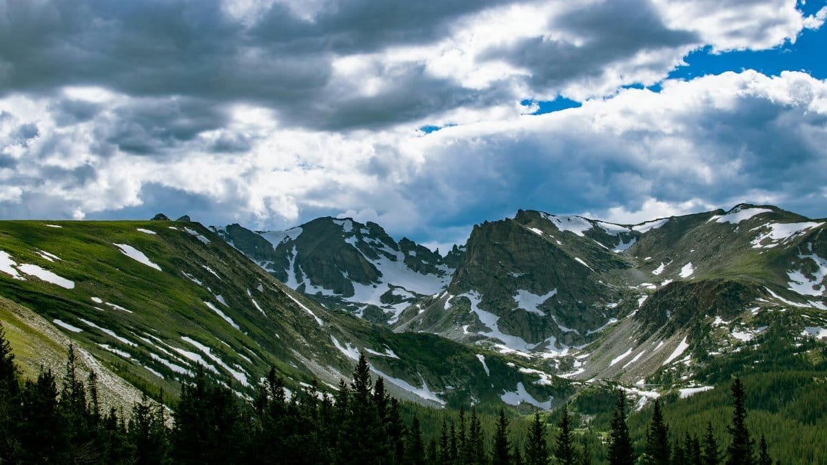 Breathtaking view of snow-capped mountains under dramatic clouds in Denver, Colorado.
